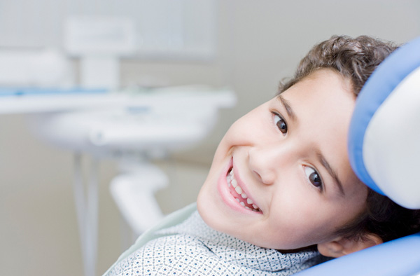 Young boy smiling with healthy teeth getting dental sealants at Brian K. Rounds, DDS in Lacey, WA